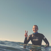 uśmiechnięty surfer na plaży po udanym przejeździe na fali podczas kursu surfingu