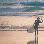 Surfer na plaży z deską surfingową