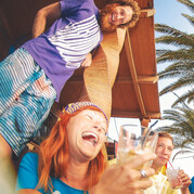 Rozmowna grupa surferów w surfcampie Fuerteventura wznosi toast za udany dzień na falach.